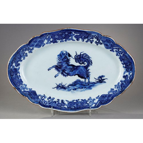 Small dish with round edge in white blue porcelain bearing a decoration of a dog probably a epagneul
standing on its hind legs on the ground or growing Lingzi mushrooms - China Qianlong period 1736/1795
