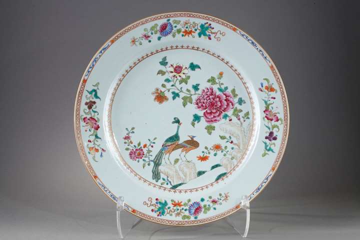 Large porcelain dish from the Famille rose with decoration of two peacocks in a landscape