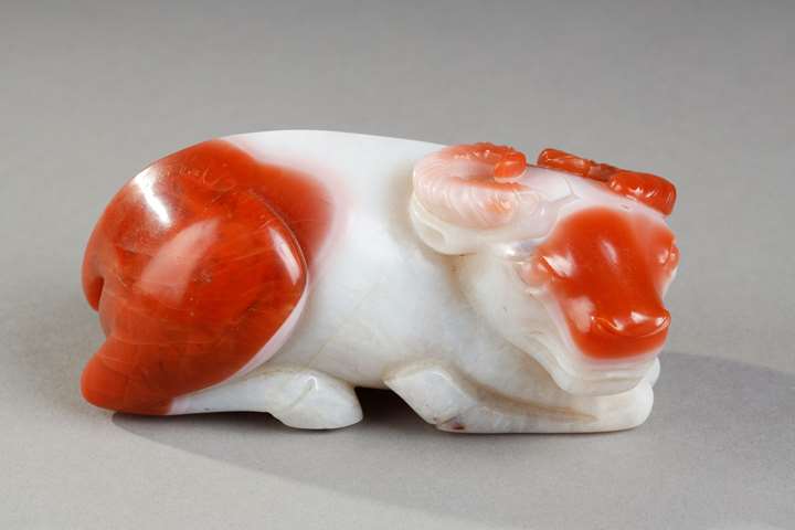 Statuette in white and rust carnelian representing a recumbent buffalo. China 19th century
10 cm long