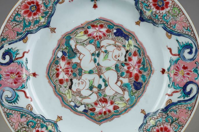 Porcelain plate Famille Rose with decoration of the two brothers Hehe in the center lying among the lotus. China circa 1730/40 | MasterArt
