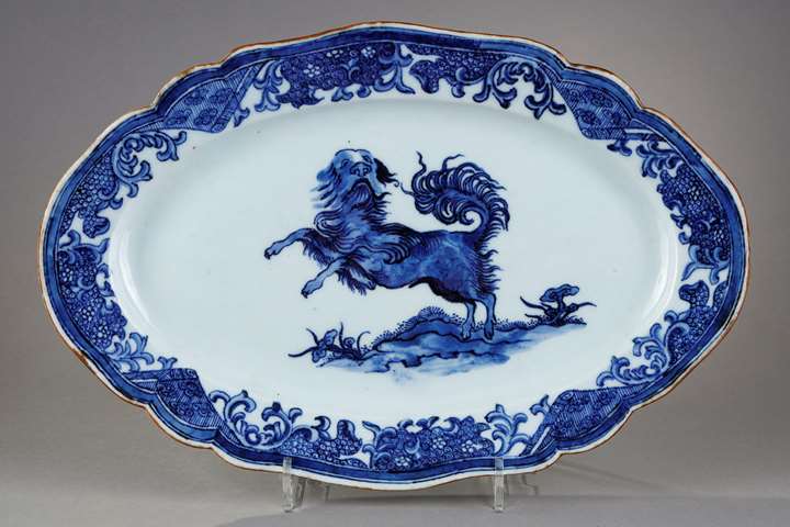 Small dish with round edge in white blue porcelain bearing a decoration of a dog probably a epagneul
standing on its hind legs on the ground or growing Lingzi mushrooms - China Qianlong period 1736/1795