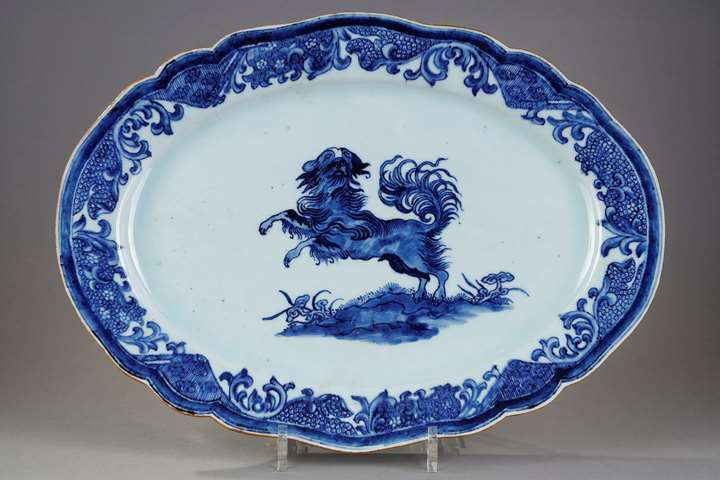 Large dish with round edge in white blue porcelain bearing a decoration of a dog probably a epagneul
standing on its hind legs on the ground or growing Lingzi mushrooms - China Qianlong period 1736/1795