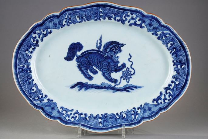 Large dish with round edge in white blue porcelain bearing a decoration of a Fo dog or Buddhist lion playing with one of the eight precious objects the sapphire symbolizing wealth   - China Qianlong period 1736/1795 | MasterArt
