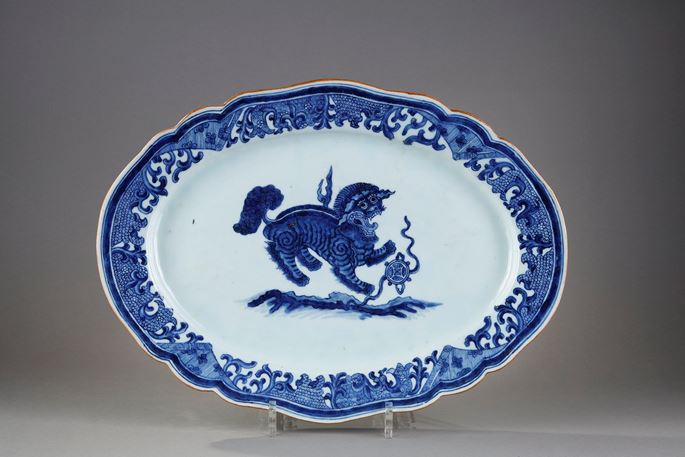 Large dish with round edge in white blue porcelain bearing a decoration of a Fo dog or Buddhist lion playing with one of the eight precious objects the sapphire symbolizing wealth   - China Qianlong period 1736/1795 | MasterArt