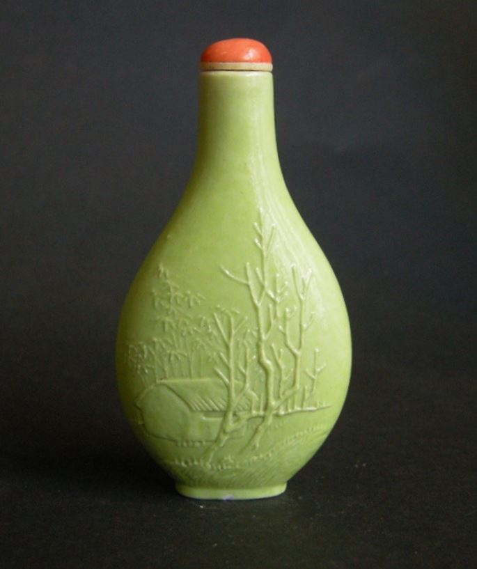 Porcelain snuff bottle in green monochrom sculpted in Wang