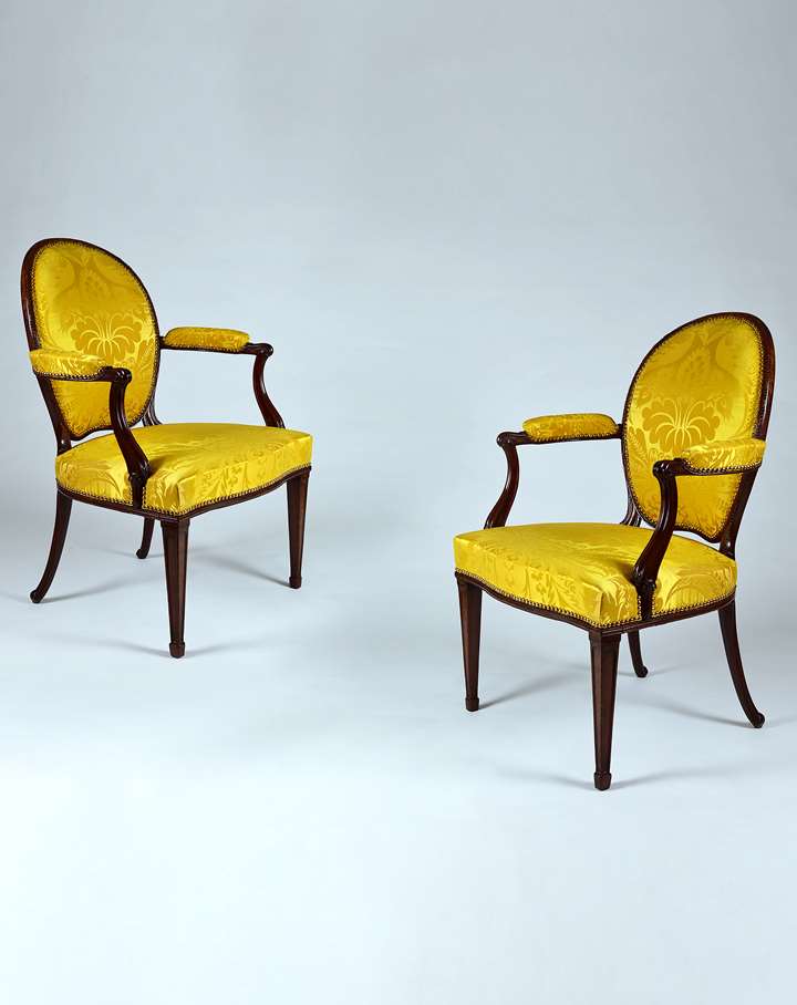 A fine pair of carved mahogany open armchairs