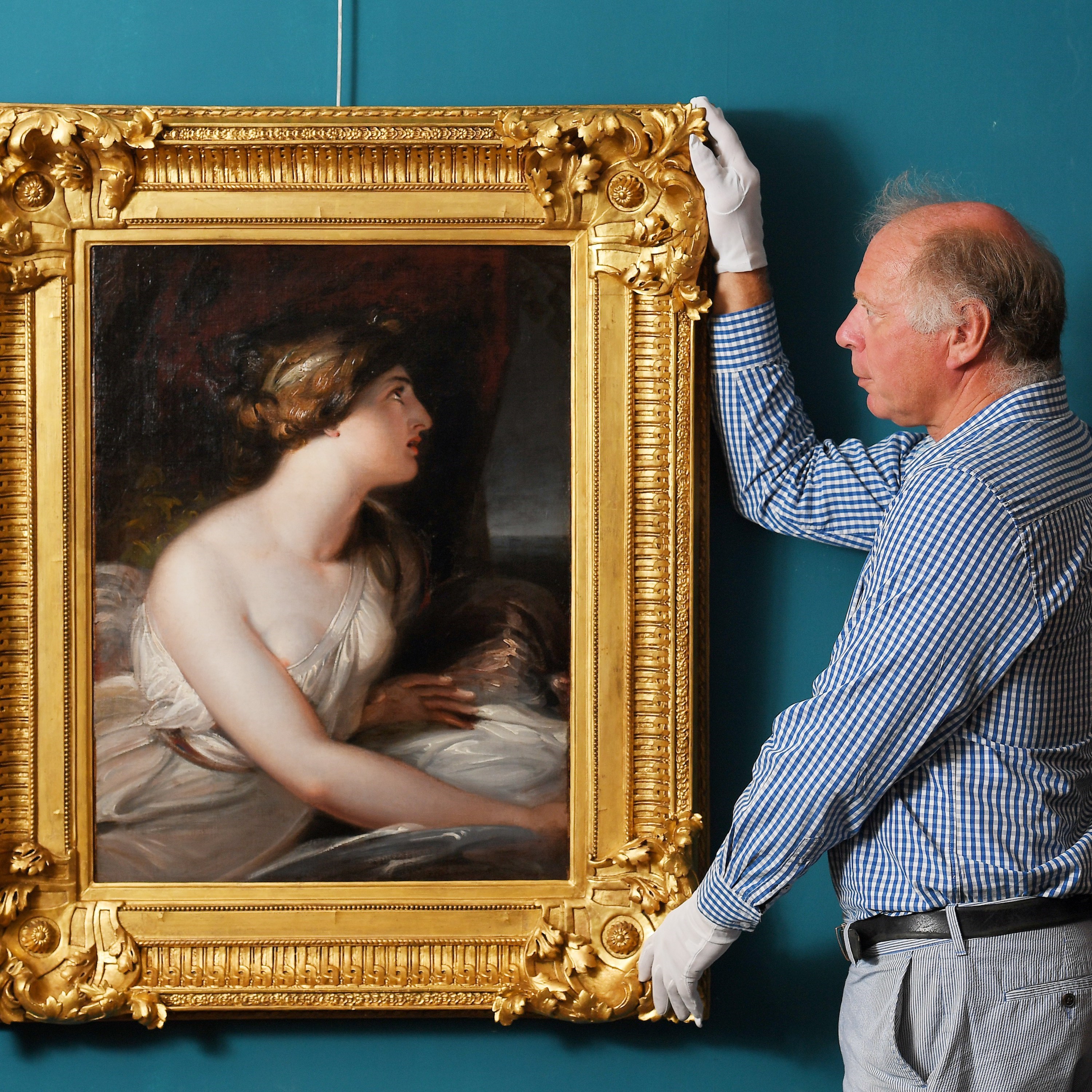 Charles Wallrock moving an artwork of a woman.